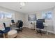 Bright office space with wood floors, multiple workstations and natural light from large windows at 9630 N Surrey Dr, Castle Rock, CO 80108