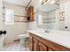 Bathroom with tiled walls, wooden vanity, window, toilet, shower, and large mirror at 1057 S Osceola St, Denver, CO 80219