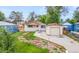 Charming single-story home featuring a detached garage, front porch, and a well-manicured lawn at 1057 S Osceola St, Denver, CO 80219