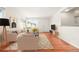 Bright living room featuring hardwood floors, neutral furniture, natural light, and a decorative rug at 1057 S Osceola St, Denver, CO 80219