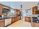 Well-lit kitchen with stainless steel appliances, tile backsplash, and custom wood cabinetry at 4934 S Flower Way, Littleton, CO 80123