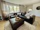 Bright living room features a comfortable leather sectional, neutral rug, and light-filled windows at 4934 S Flower Way, Littleton, CO 80123