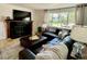 Comfortable living room featuring a leather sectional sofa, fireplace, and light-filled windows at 4934 S Flower Way, Littleton, CO 80123