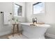 Bright bathroom boasts a soaking tub with decor and views from two large windows at 1157 Jersey St, Denver, CO 80220