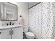 Stylish bathroom with a marble countertop vanity and a vibrant polka dot shower curtain at 1157 Jersey St, Denver, CO 80220