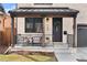 Charming front porch with stone columns, black metal railing, and a cozy seating area at 1157 Jersey St, Denver, CO 80220
