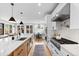 Modern kitchen featuring an island with a marble countertop, stainless steel appliances, and ample lighting at 1157 Jersey St, Denver, CO 80220