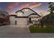 Charming two-story white home with a three-car garage and a welcoming front porch at sunset at Reunion Freunion F Mobile St, Commerce City, CO 80022