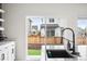 Modern kitchen with backyard view, light cabinets, spacious countertops, black hardware, and contemporary faucet at Reunion Freunion F Mobile St, Commerce City, CO 80022