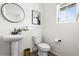 A stylish powder room features a pedestal sink, round mirror, and modern decor at Reunion Freunion F Mobile St, Commerce City, CO 80022