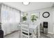 Bright dining room with light gray walls, wood-look flooring, white curtains, and decor at 14791 E Security Pl, Aurora, CO 80011