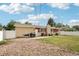Back exterior of home with a brick chimney, small patio, and white picket fence at 14791 E Security Pl, Aurora, CO 80011