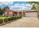 Well-kept single-Gathering home with a red exterior, stone accents, tidy landscaping and an extended driveway at 14791 E Security Pl, Aurora, CO 80011