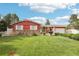 A cozy single-story red home with beautiful green lawn, stone accents, a decorative fountain and manicured shrubbery at 14791 E Security Pl, Aurora, CO 80011