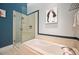 Stylish bathroom featuring a tub and glass shower with blue accent paint at 1720 Wazee St # 3B, Denver, CO 80202