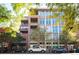 Modern multi-story condo building featuring large windows and balconies, surrounded by lush green trees and sidewalks at 1720 Wazee St # 3B, Denver, CO 80202