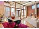 Spacious living room featuring exposed brick, hardwood floors, large windows, and a dining table at 1720 Wazee St # 3B, Denver, CO 80202