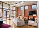 Bright living room featuring exposed brick, hardwood floors, large windows, and a comfortable seating area at 1720 Wazee St # 3B, Denver, CO 80202
