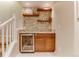 Basement bar features wood shelves, stone backsplash, sink, wood cabinets and a beverage refrigerator at 10882 Bullock Ct, Parker, CO 80134