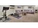 Finished basement with carpet, gray sectional, mounted television and exercise equipment at 10882 Bullock Ct, Parker, CO 80134