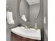 Modern half-bathroom with a stylish vanity, oval mirror, and neutral gray walls at 10882 Bullock Ct, Parker, CO 80134