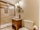 Bathroom with a vessel sink, framed mirror, wood cabinet, tiled shower, and bronze fixtures at 10882 Bullock Ct, Parker, CO 80134