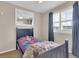 A cozy bedroom with a comfortable bed, blue curtains, and natural light at 10882 Bullock Ct, Parker, CO 80134