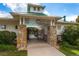 View of the community clubhouse entrance with stone pillars and a glimpse of the pool at 10882 Bullock Ct, Parker, CO 80134