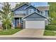 Exterior view of a two-story home with blue siding, stone accents, and a spacious two-car garage at 10882 Bullock Ct, Parker, CO 80134