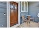 Cozy front porch with a stained wood door, chairs, and a side table offering a welcoming entrance at 10882 Bullock Ct, Parker, CO 80134