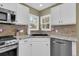 Corner of a kitchen featuring white cabinets, granite countertops, and stainless steel appliances at 10882 Bullock Ct, Parker, CO 80134