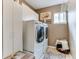 Well-organized laundry room with front-loading washer/dryer, storage cabinets, and bright natural light at 10882 Bullock Ct, Parker, CO 80134
