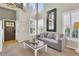 Bright living room with vaulted ceilings, large windows, neutral tones, and a stained wood front door at 10882 Bullock Ct, Parker, CO 80134