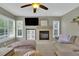 Cozy living room with a fireplace, TV, plush couches, and bright windows at 10882 Bullock Ct, Parker, CO 80134