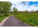 Scenic view of a walking path through a lush green area with beautiful homes in the background at 10882 Bullock Ct, Parker, CO 80134