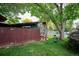 A fenced-in backyard featuring a greenhouse, mature trees and well-maintained lawn at 850 Idalia Cir, Aurora, CO 80011
