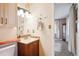 Well-lit bathroom featuring a wood vanity, bright mirror and natural stone accents at 850 Idalia Cir, Aurora, CO 80011