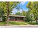 Charming single-story home with lush front yard, brick accents, and mature trees at 850 Idalia Cir, Aurora, CO 80011