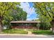 Charming single-story home with lush front yard, brick accents, and mature trees at 850 Idalia Cir, Aurora, CO 80011