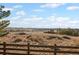 A sprawling landscape beyond a wooden fence showcases vast open space and distant homes at 12071 S Tallkid Ct, Parker, CO 80138