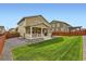Backyard featuring well maintained lawn, wooden fence, stone landscape border, and patio at 14067 Hudson St, Thornton, CO 80602