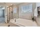 Bright primary bathroom with soaking tub and glass-enclosed shower with a window at 14067 Hudson St, Thornton, CO 80602