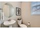Charming powder room with pedestal sink, artwork, and natural light from the window at 14067 Hudson St, Thornton, CO 80602