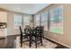 Bright dining area with dark wood table, matching chairs, and natural light from three large windows at 14067 Hudson St, Thornton, CO 80602