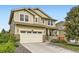 Inviting two-story home with a manicured lawn, charming front porch, and attached two-car garage at 14067 Hudson St, Thornton, CO 80602