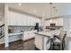 Well-lit kitchen featuring white cabinets, granite countertops, stainless steel appliances, and a center island at 14067 Hudson St, Thornton, CO 80602