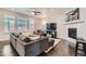Cozy living room featuring a plush gray sectional, hardwood floors, and a fireplace at 14067 Hudson St, Thornton, CO 80602