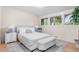 Bright bedroom with neutral tones, large windows offering a view of trees, and hardwood floors and an area rug at 4405 Gardenia St, Golden, CO 80403