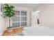 Cozy bedroom with white walls, hardwood floors, a modern sliding closet door, and a view into the bathroom at 4405 Gardenia St, Golden, CO 80403
