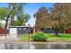 Charming single-story home featuring a lush front yard and attached garage, freshly painted with modern colors at 4405 Gardenia St, Golden, CO 80403